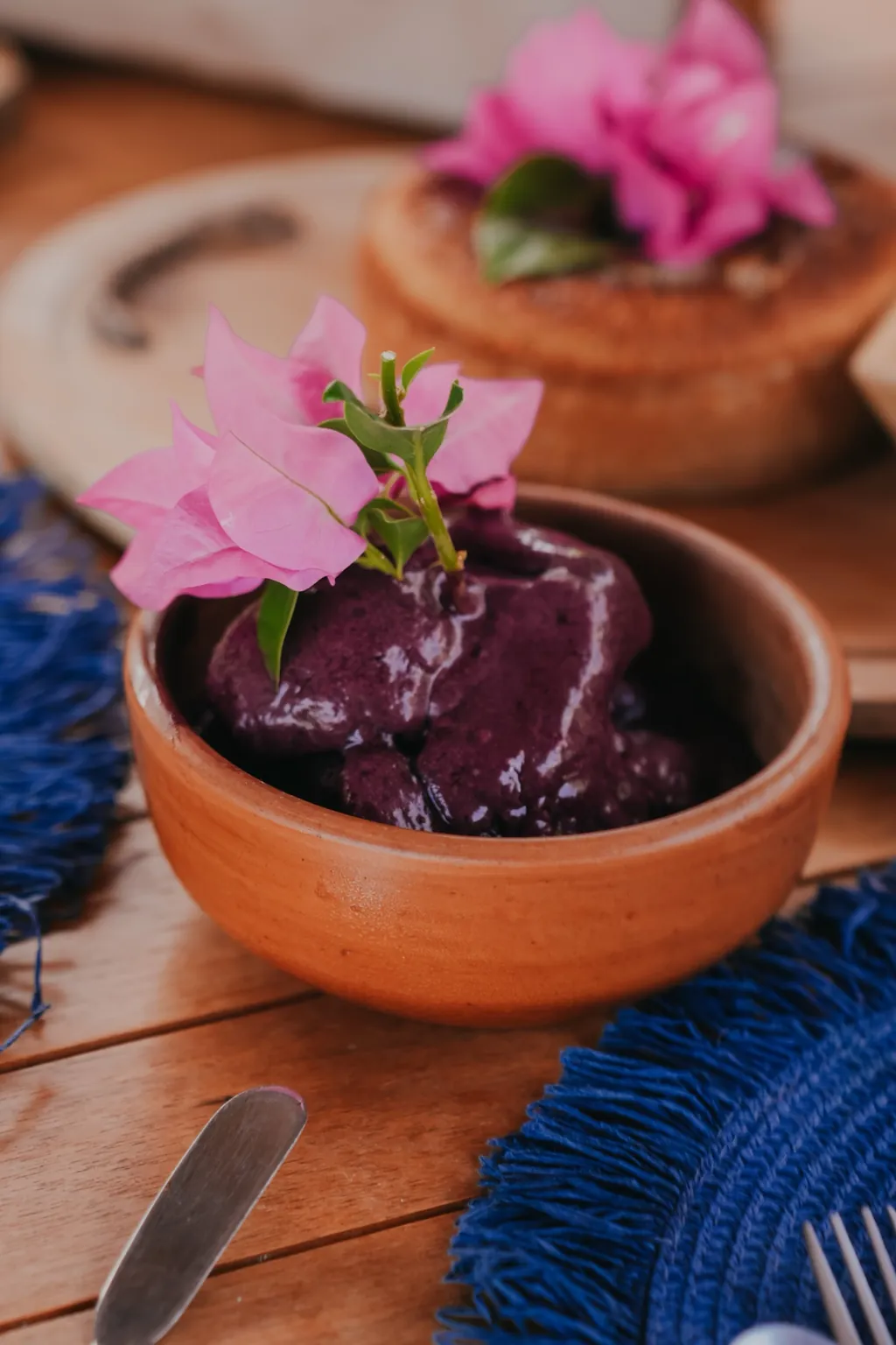 Regional breakfast: açaí in a clay bowl with a bougainvillea flower