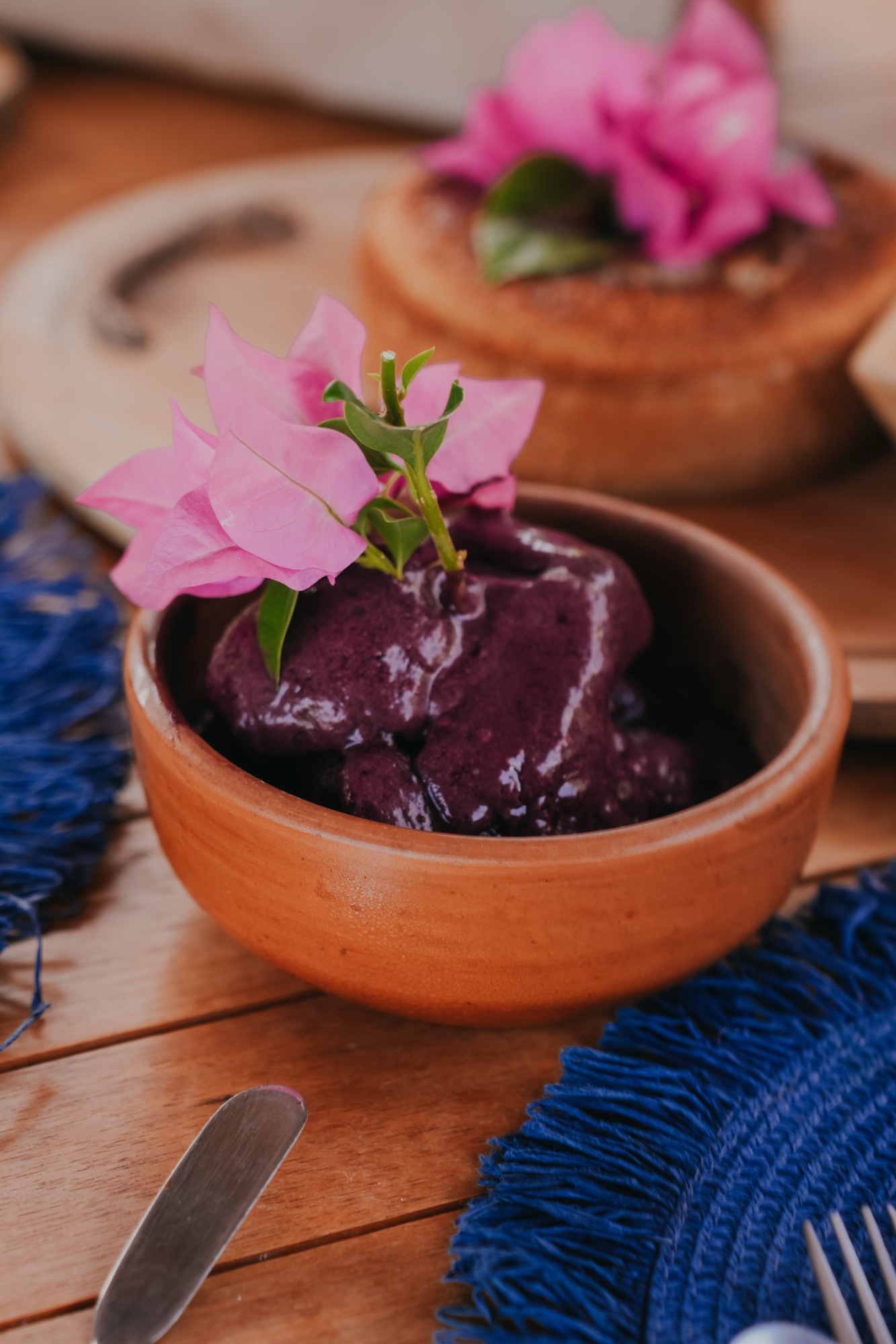 Café da manhã regional: açaí em tigela de barro com flor de buganvília