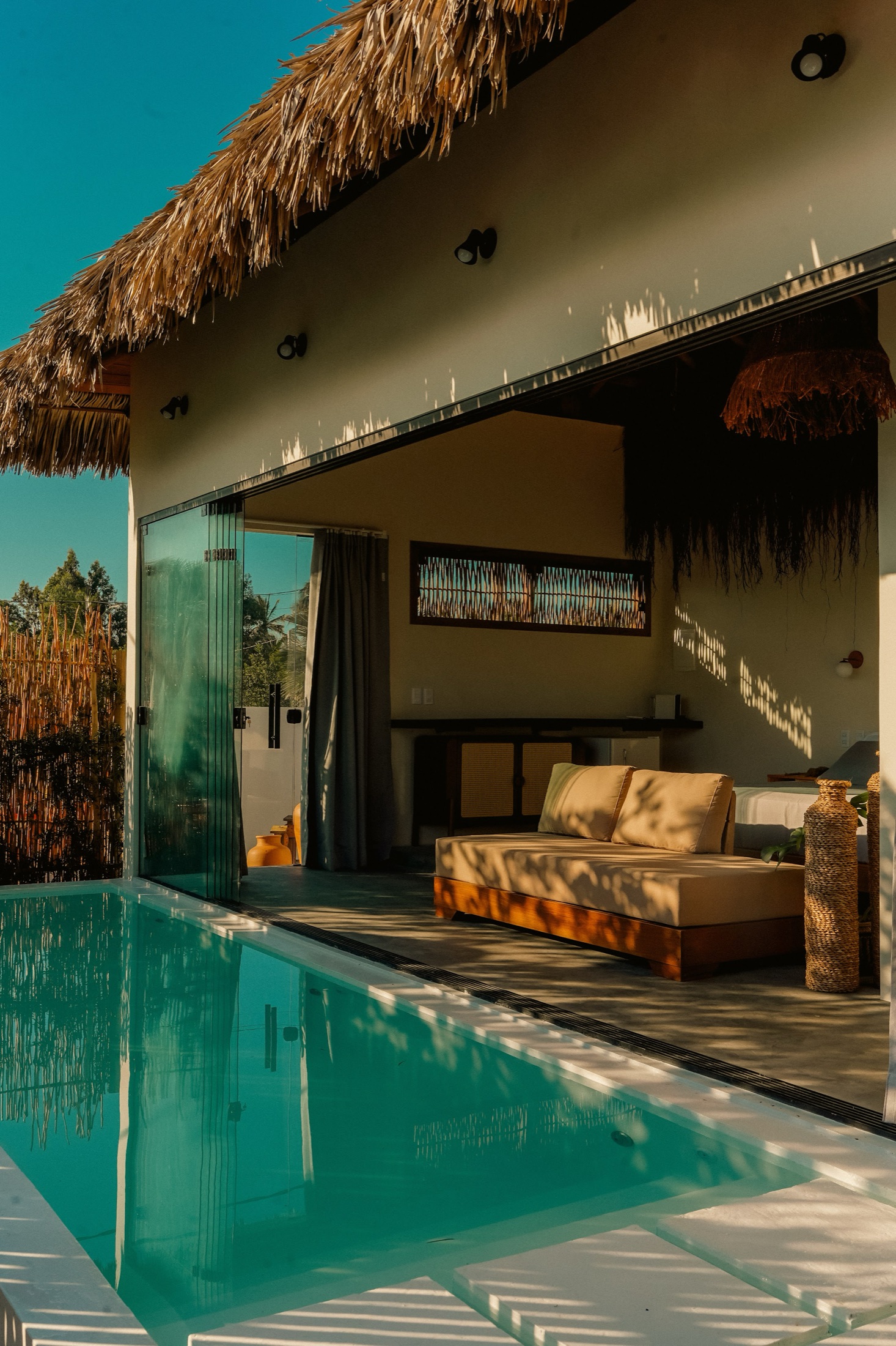 Chalé Private: parede de vidro, piscina privativa e área de estar ao pôr do sol